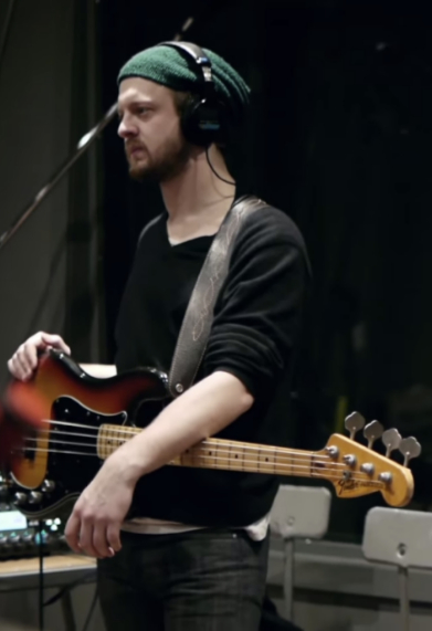 Bryan Percivall holding an electric bass on stage