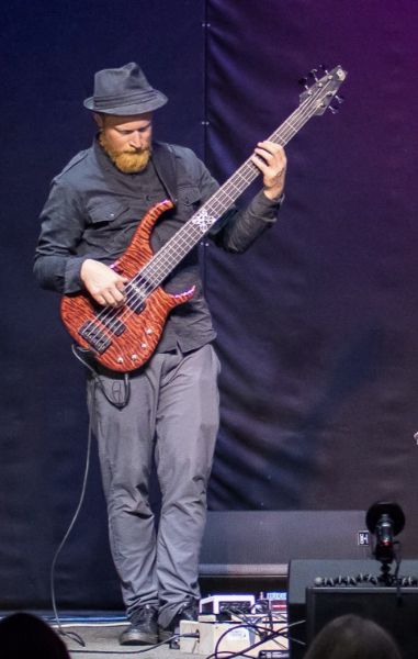Charlie Mertens performing with an electric bass