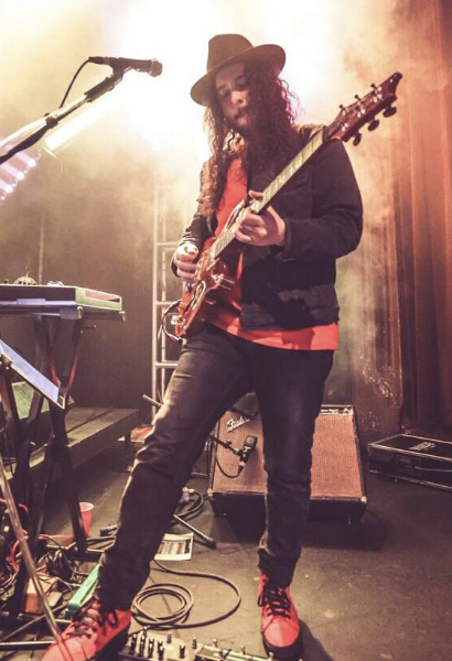 Jordan Linit performing on stage with an electric guitar