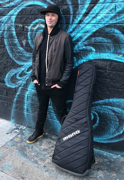 Nate Edgar standing beside a bass case