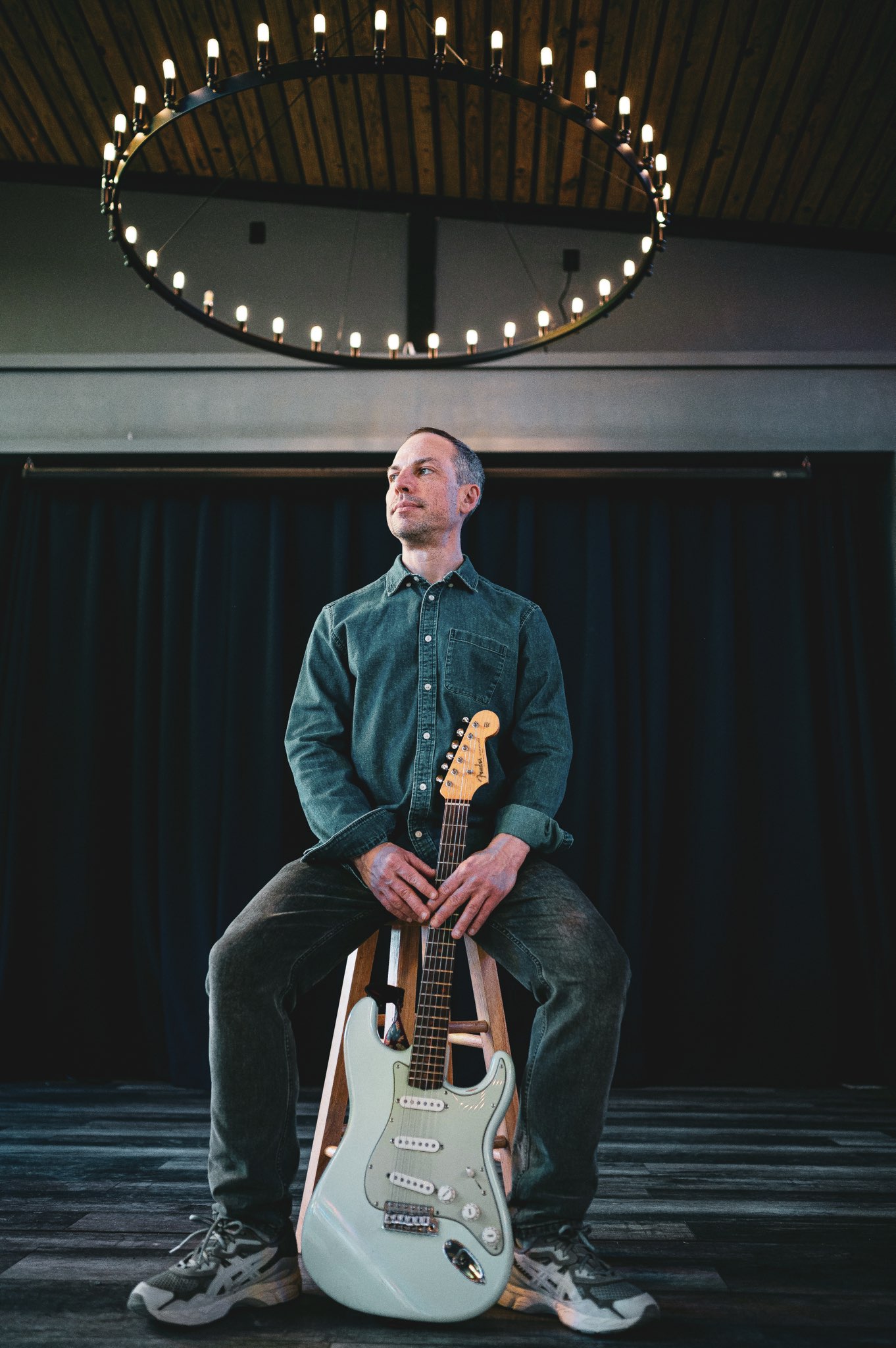 Ryan Jalbert seated with an electric guitar